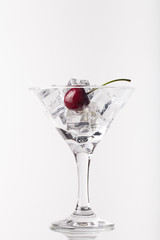 Cherry berries in a martini glass on white background