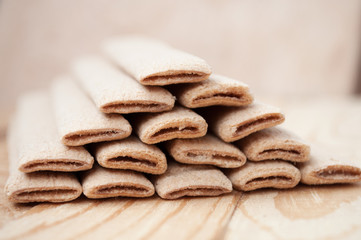Biscuit sticks with filling on a wooden surface
