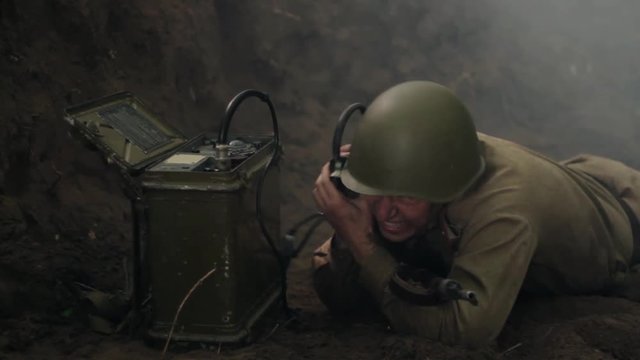 Soviet soldier during combat action crawls to portable radio.