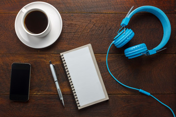 Top view pen,note paper,cup of coffee,smartphone or mobile phone on wood.