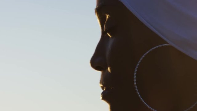 Close view of african american females face as she enjoys a sunset view, in slow motion
