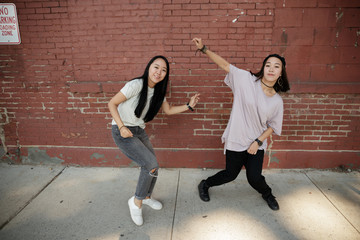 Young Asian woman dancing hip hop in city