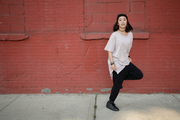 Young Asian woman dancing hip hop in city