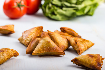 Gold and brown deep fried chicken samosas.