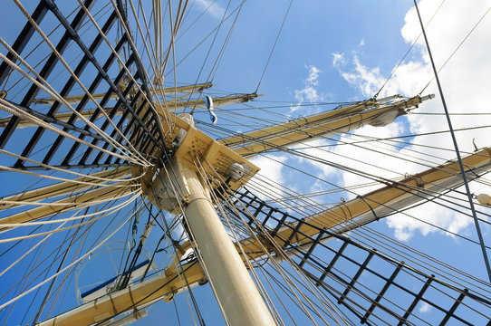 Masts of the old sailing ship on sky background