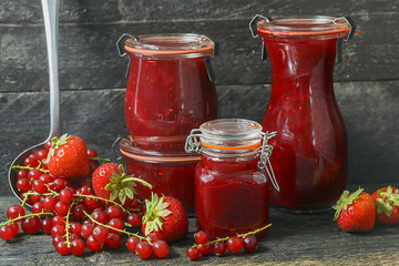  Marmelade im Glas mit frischen Beeren,  rustikaler Hintergrund