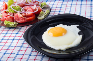 Simple homemade breakfast - fried egg and tomato salad