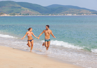 Happy Couple Running on Tropical Beach at Sunset