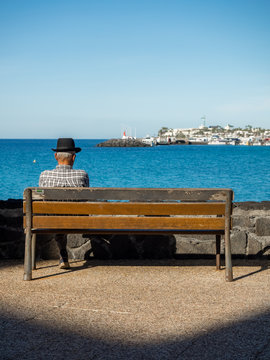 Old Man Sitting On A Wooden Bench