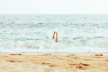 Woman jumping in the wave on the beautiful beach