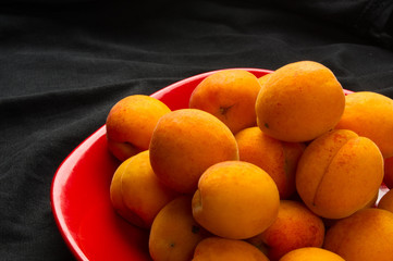 fresh apricots in red plate