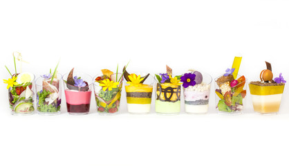 mini canapes in plastic cups decorated with edible flowers