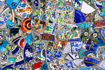 Fototapeta na wymiar wall with broken ceramic plates colored fragments