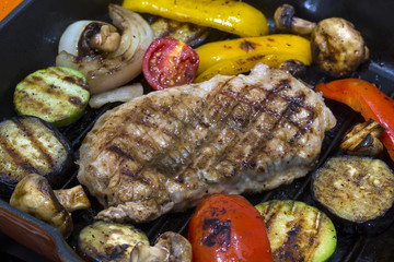 Cooking steak and vegetables on grill pan