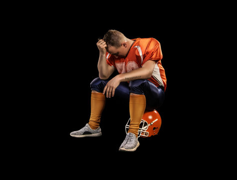 American Football Player Sitting On Helmet Isolated