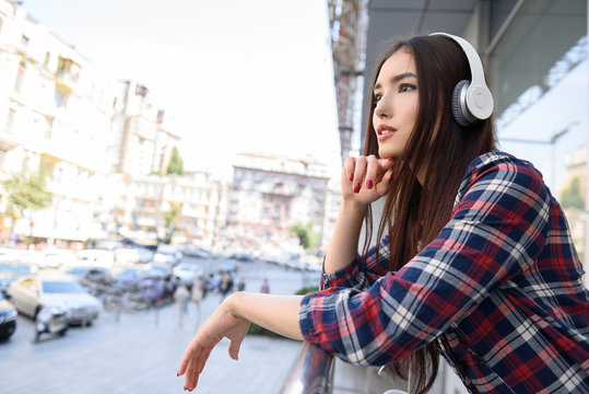 Cheerful woman relaxing with earphones outdoors