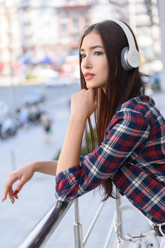 Dreamful girl listening to song from headphones