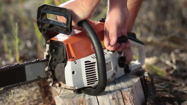 Close up man hands starting chainsaw