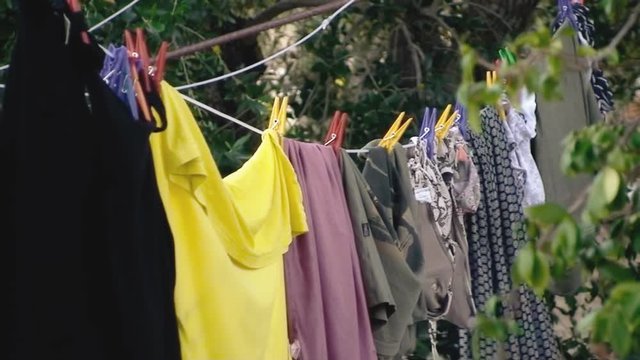 Clean clothes (laundry) hanging from a dryer outside, shaken by the wind. Detail shot.
