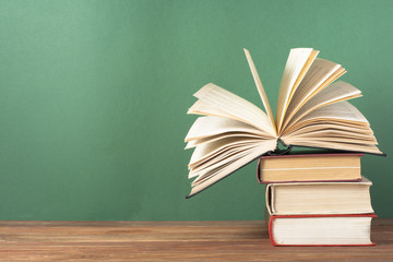 Open book, hardback books on wooden table. Education background. Back to school. Copy space for text.