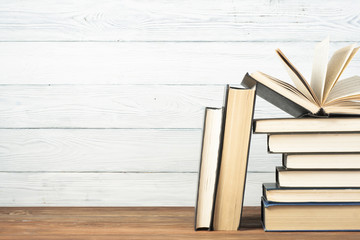 Open book, hardback books on wooden table. Education background. Back to school. Copy space for text.