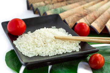 Oriental set of rice, tomatoes, chopsticks, green leaf and trans