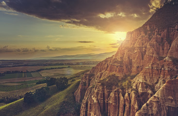 Scenic setting sun with lens flare effect over the valley near the badlands Red Ravine (Romanian:...