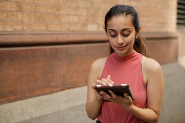 Young woman in city using tablet computer