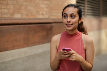 Young woman in city texting cell phone