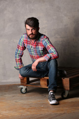 Bearded man in colorful shirt sitting with crossed legs