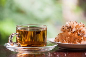 Hot tea with fried sweet pastry on wooden table