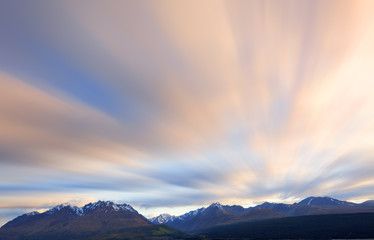 Long exposure of cloud movement above snow capped mountains.