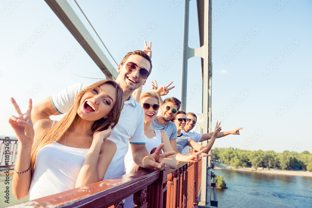 Wall mural joyful excited best friends having fun and showing v-sign with f