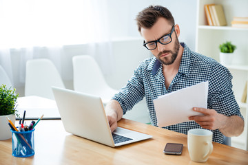 Portrait of concentrated businessman in glasses with laptop read