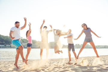 outing near waterfront,  joyful girlfriends with boyfriends jump