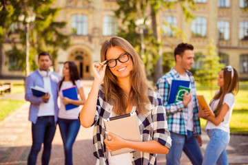 smart happy girl standing near university and her friends and ad