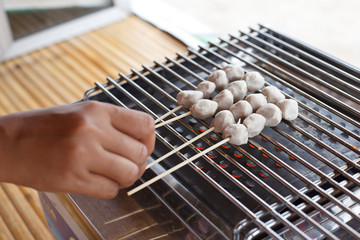 Meatballs on skewers being grilled on a barbecue