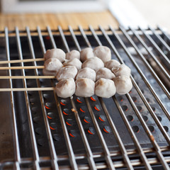 Meatballs on skewers being grilled on a barbecue