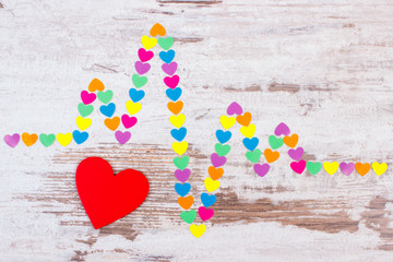 Cardiogram line of paper hearts on wooden background, medicine and healthcare concept