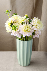 Bouquet of yellow dahlia flowers in blue ceramic vase.