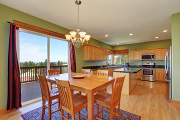 Dining room and kitchen with green walls and hardwood floor