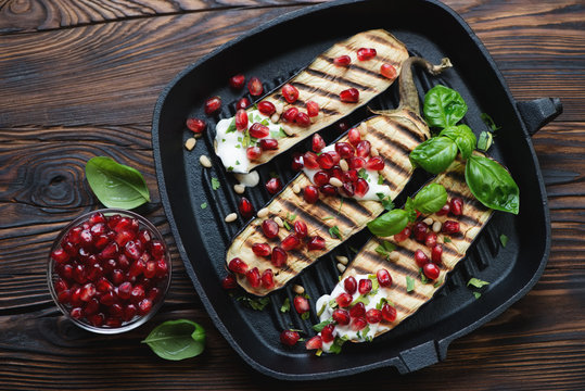 Grilled eggplant with pomegranate seeds, sour cream and basil