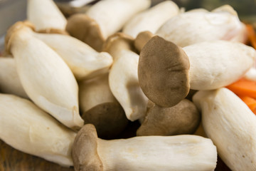King oyster mushroom, Pleurotus eryngii on chopping wood board and many kind of vegetables in background