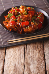 Asian cuisine: Pork with sauce with vegetables on a plate. vertical
