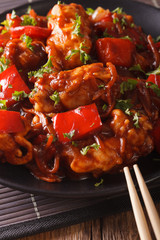 pork in sweet and sour sauce with peppers, carrots and onions macro. vertical
