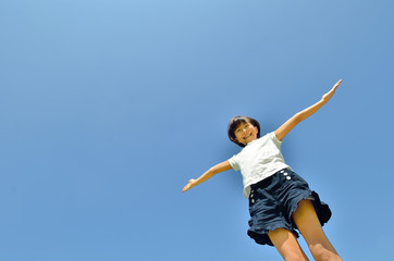 青空で手を広げる女の子