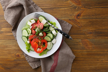 Fresh vegetables salad in bowl on wood