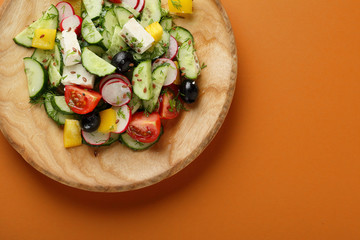 Greek salad on wooden plate
