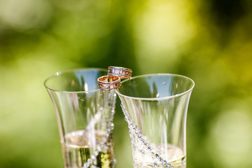 Wedding rings  lie on the glasses of champagne