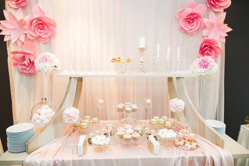 Delicious and tasty dessert table with cupcakes shots at reception closeup